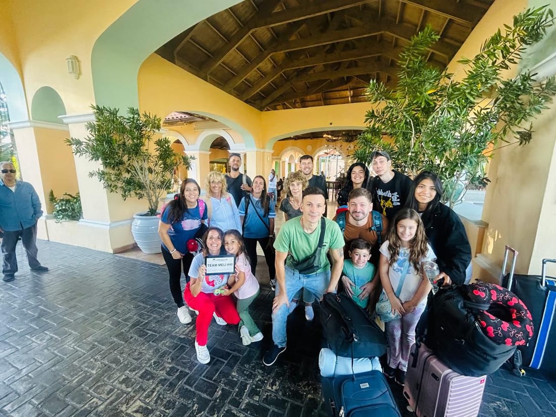 Large group met at a resort with a welcome name board